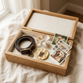 Open oak keepsake box lined with linen, holding a dog collar, a tuft of fur, photos and a gold nose print